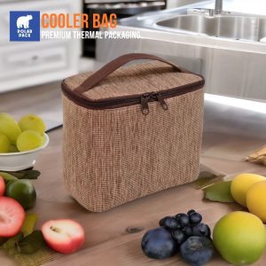 Cooler bag Polar Pack warna cokelat dengan resleting ganda dan handle, diletakkan di atas meja kayu dengan berbagai macam buah segar di sekitarnya.