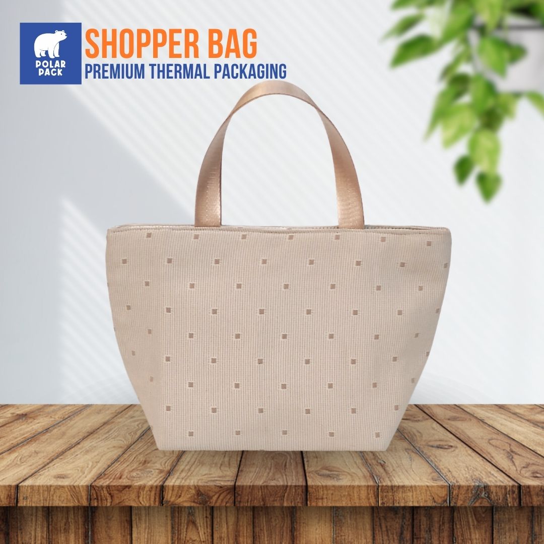 Tas belanja atau shopper bag thermal dari Polar Pack berwarna krem dengan handle jinjing, diletakkan di atas meja kayu, cocok untuk belanja atau jalan-jalan.